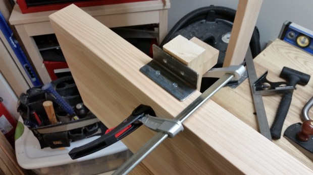My shop-made sharpening depth stop block makes a great backerboard for installing angle irons.